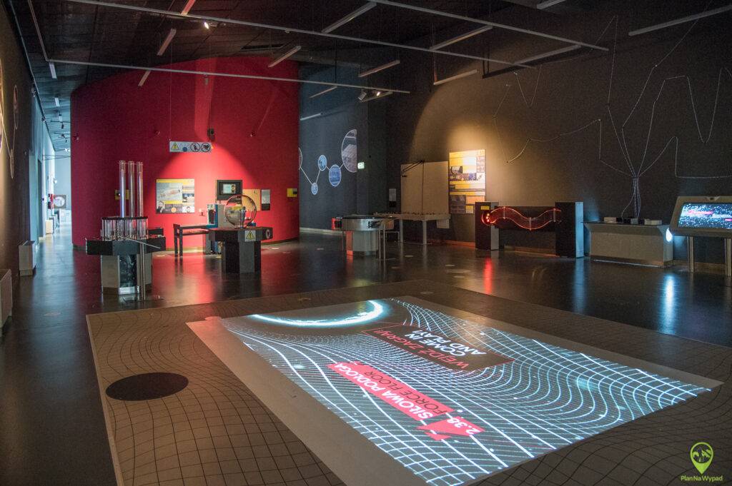 Zwiedzający korzystający z nowoczesnego, interaktywnego stanowiska multimedialnego i ekranów dotykowych na wystawie naukowo-technicznej w EC1 Łódź.