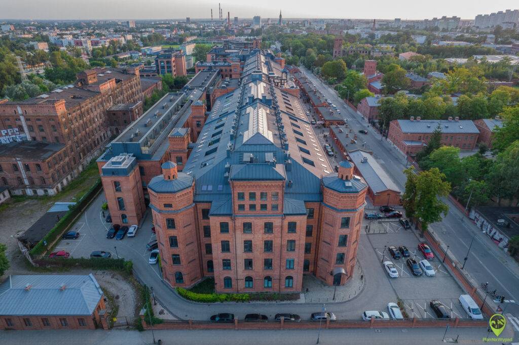 Panorama Księżego Młyna Łódź z widokiem na monumentalne, zrewitalizowane fabryki Scheiblera przekształcone w nowoczesne lofty.