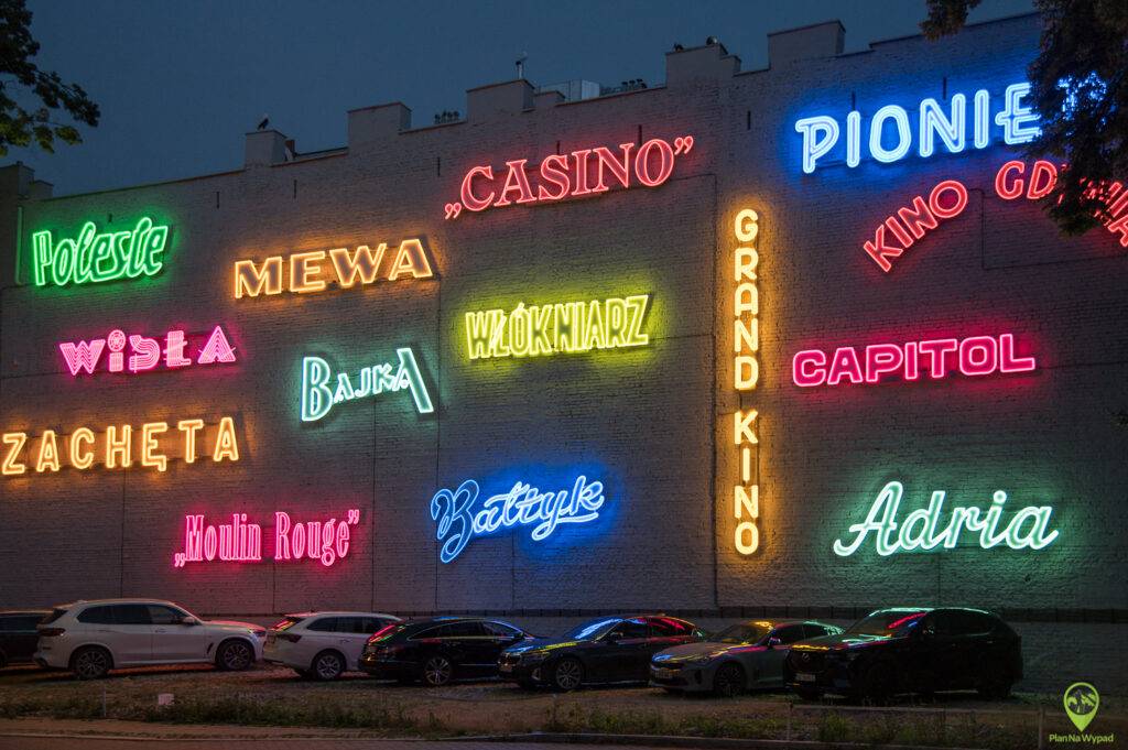 Ściana świecących nocą neonów w galerii neonów w Łodzi.