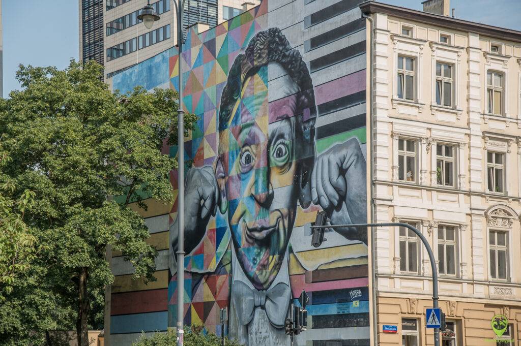 Wielkoformatowy, kolorowy mural przedstawiający postać Rubinsteina na ścianie kamienicy w Łodzi.