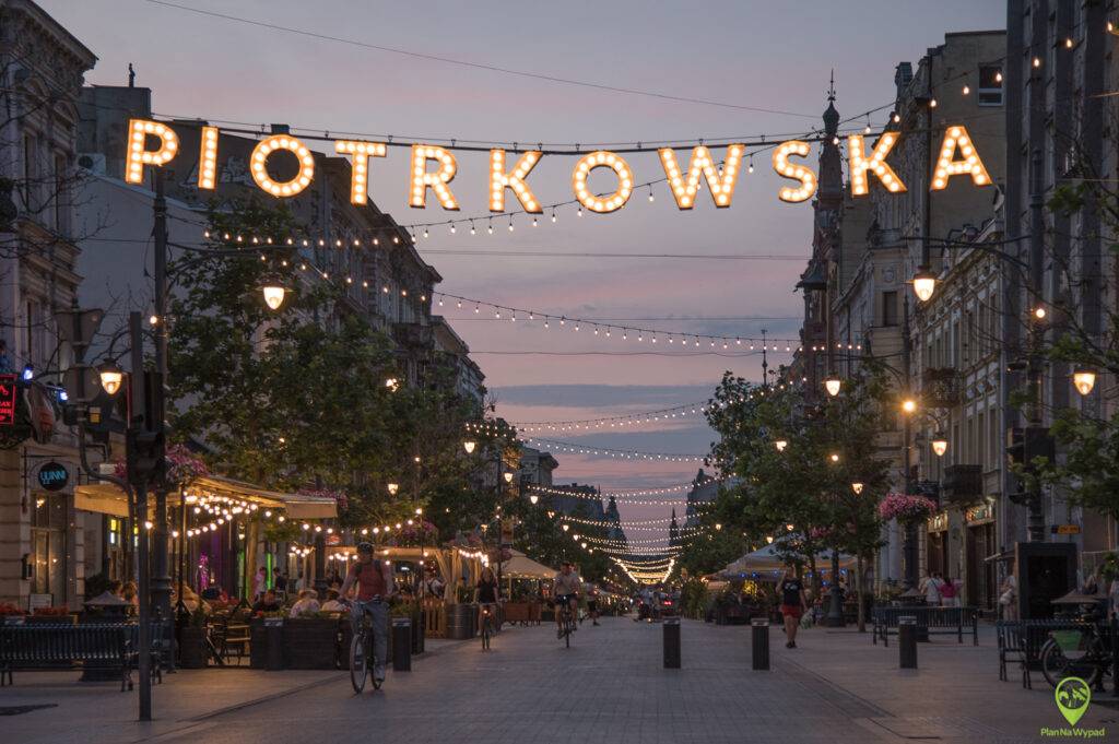 Ulica Piotrkowska nocą - podświetlony napis i girlandy nad deptakiem.